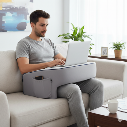 Man comfortably using the Soffice Desk with his laptop on top, while sitting on a sofa